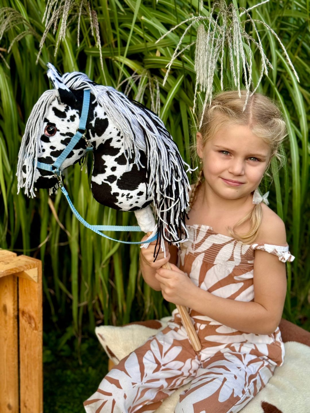 Dziewczynka bawiąca się własnoręcznie uszytym konikiem hobby horse typu Teksas
